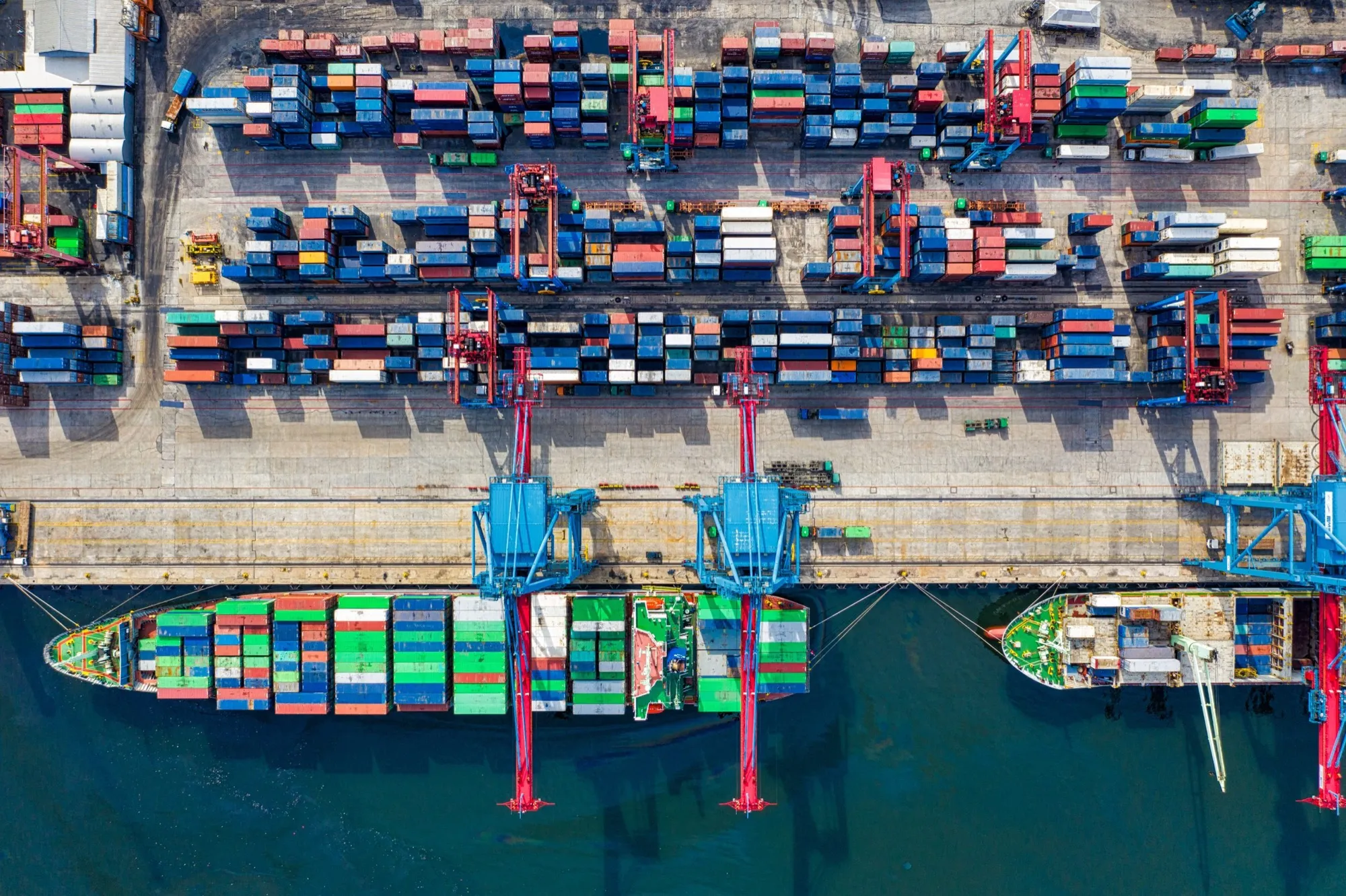 Aerial view of a container port with cranes and a cargo ship