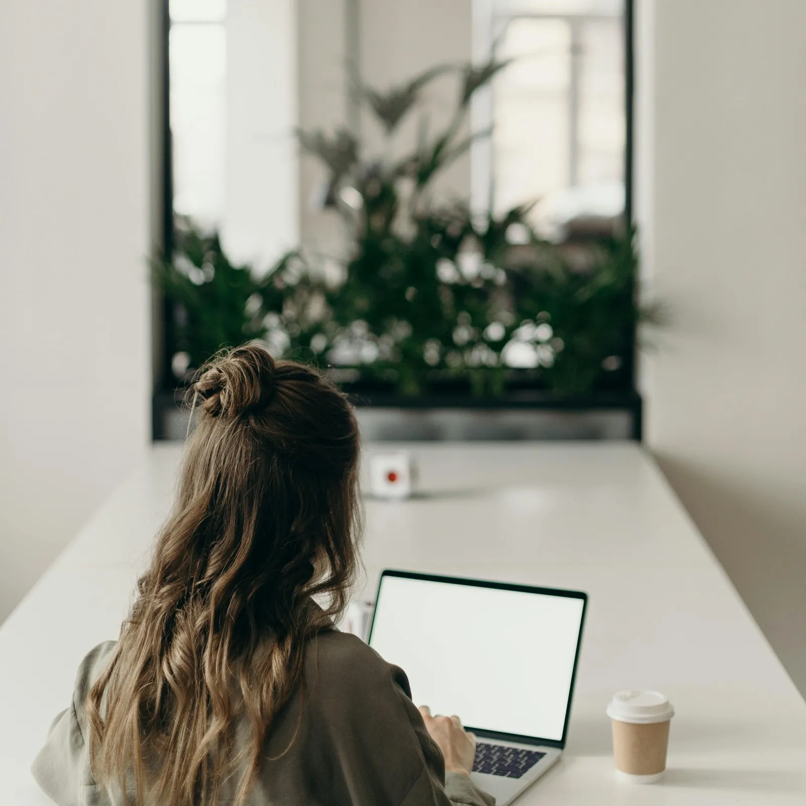 Person working on a laptop at a bright desk